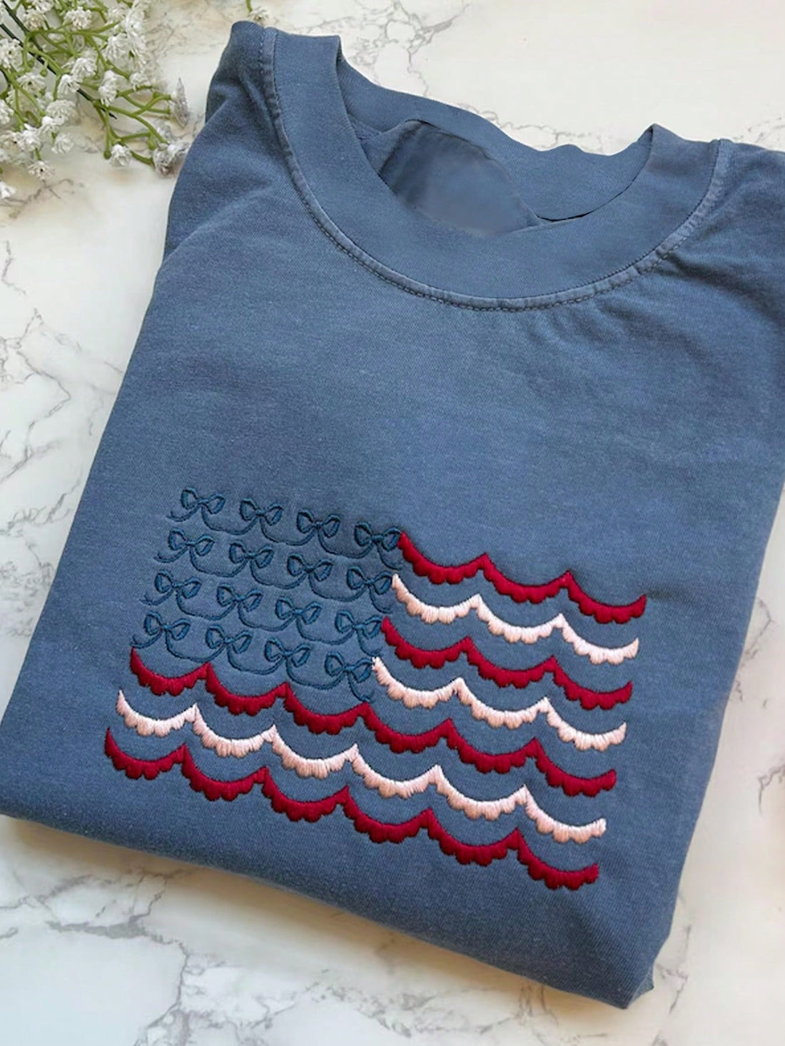 Celebrate summer in style with this playful embroidered American flag T-shirt, perfect for July 4th festivities and backyard BBQs. Its vibrant design adds a fun patriotic flair to your casual look, making every gathering feel extra special. Comfortable and eye-catching, it’s your go-to tee for sunny days and star-spangled nights.