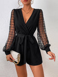 Elevate your casual wardrobe with this striking plaid mesh romper. Featuring a deep V-neck overlap collar, voluminous bishop sleeves, and a cinched waist with belt, it delivers effortless sophistication. The contrast mesh detailing adds visual interest, while the high-waist cut flatters your silhouette. Crafted from a breathable knitted fabric blend with slight stretch for comfort, this short romper transitions seamlessly from day to night. Perfect for spring gatherings and weekend adventures.