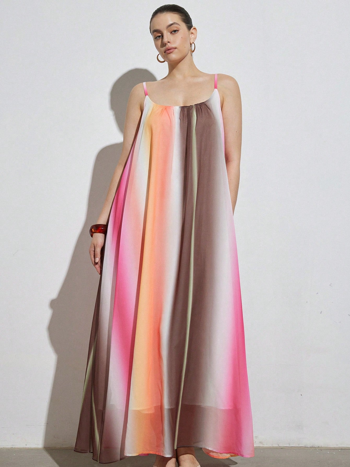 Celebrate vibrant style and comfort with this plus-size maxi dress featuring a playful rainbow gradient. Its flattering V-neck and sleeveless design keep you cool and confident, perfect for casual outings or beach days. Flowing fabric moves with you, making every step feel like a breeze of fun and color.