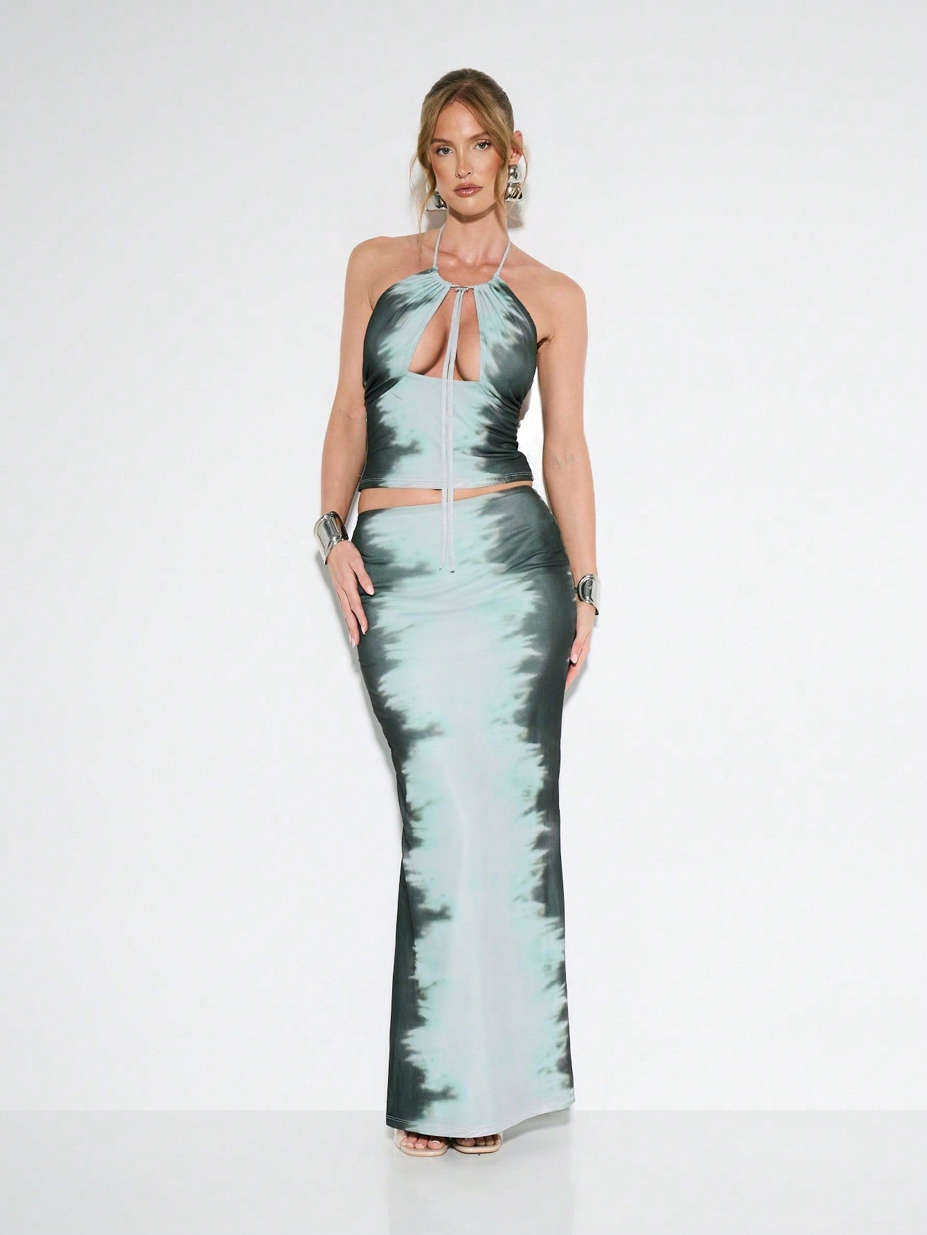 Turn heads this season in our stunning satin tie-dye two-piece set! The halter neck crop top hugs your curves with effortless style, while the high-waist maxi skirt elongates your silhouette and keeps things classy. Perfect for summer soirées, beach parties, or any occasion where you want to make a splash. The luxe satin finish catches the light beautifully, and those mesmerizing tie-dye patterns ensure you'll stand out from the crowd. Mix, match, or wear together—this versatile duo is your new go-to for lo