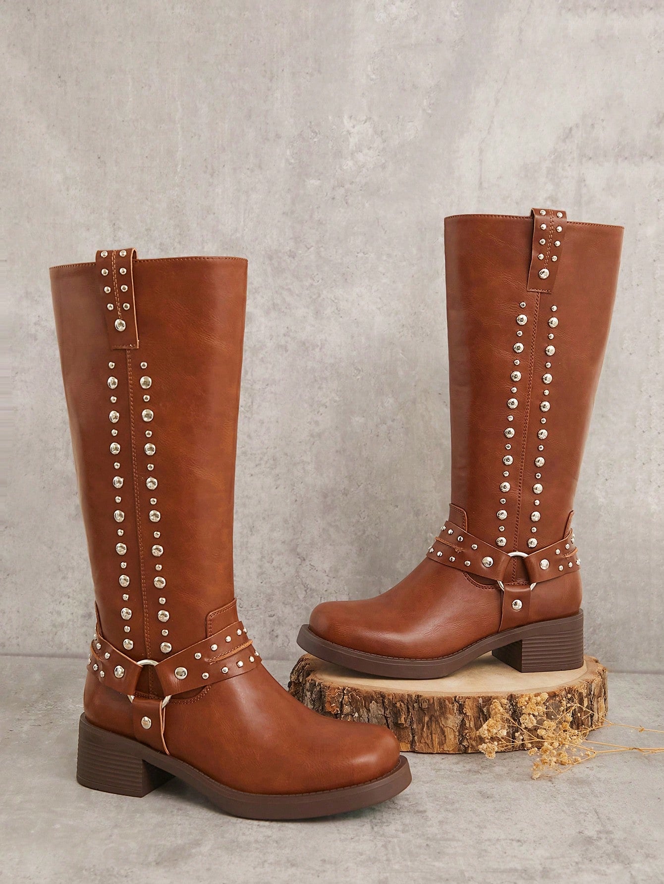 Step out with confidence in these Stylish Two-Lines Studded Tall Boots, designed to turn heads. Featuring bold stud details and a strapped harness, they add an edgy twist to any outfit. Perfect for those who love to make a daring fashion statement while staying comfortable and chic.