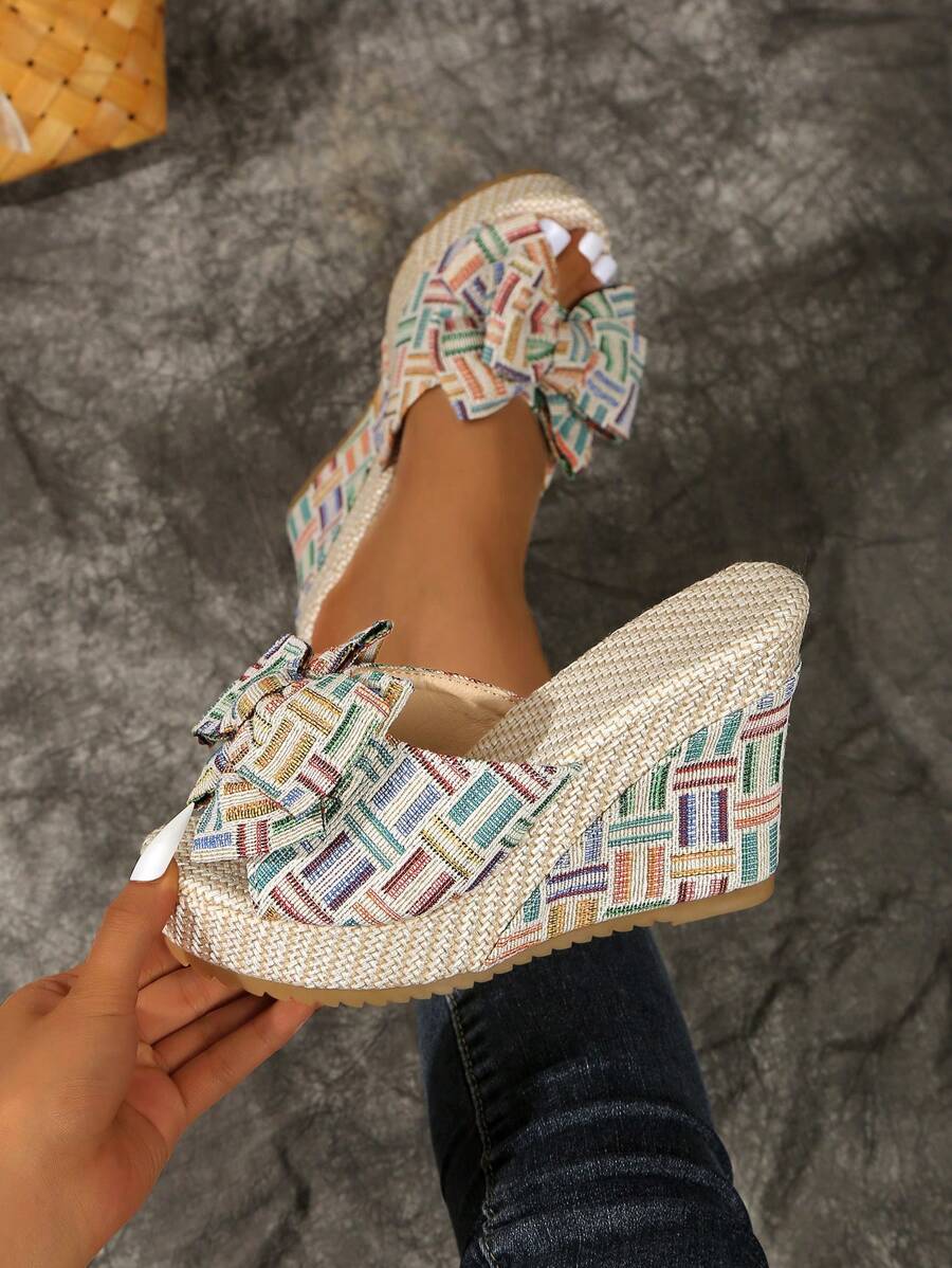 Multicolor bowknot wedge slide sandals with raffia-like platform and open toe.