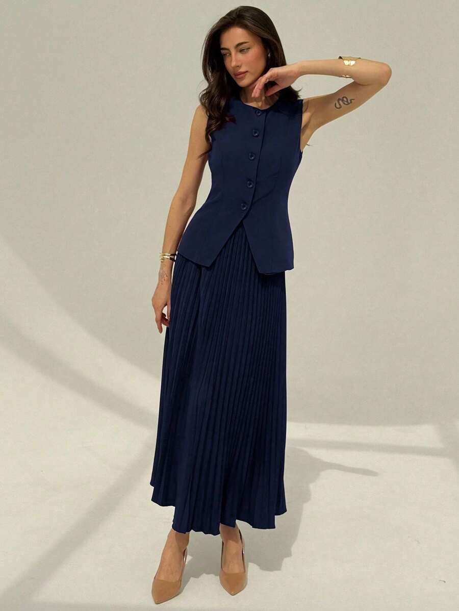 Front view of navy sleeveless waistcoat and pleated maxi skirt suit