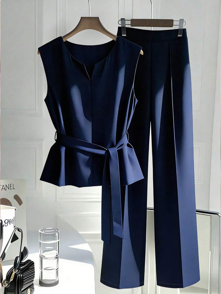 Perfect for the modern professional, this retro-inspired 2-piece set combines timeless style with practical comfort. The sleeveless camisole features a notched neckline and cinched waist design that flatters your silhouette, while the coordinating long pants complete the sophisticated look. Equipped with functional belt loops, pockets, and a zipper for everyday ease. Made from durable 100% polyester in versatile navy blue.
