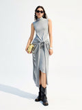 Turn heads with this playful sleeveless turtleneck dress, featuring a chic twisted waist and eye-catching metal ring detail. Its sleek grey hue adds a modern touch, while the long silhouette keeps things effortlessly elegant. Perfect for making a stylish statement wherever you go!