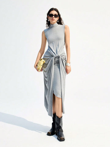 Turn heads with this playful sleeveless turtleneck dress, featuring a chic twisted waist and eye-catching metal ring detail. Its sleek grey hue adds a modern touch, while the long silhouette keeps things effortlessly elegant. Perfect for making a stylish statement wherever you go!