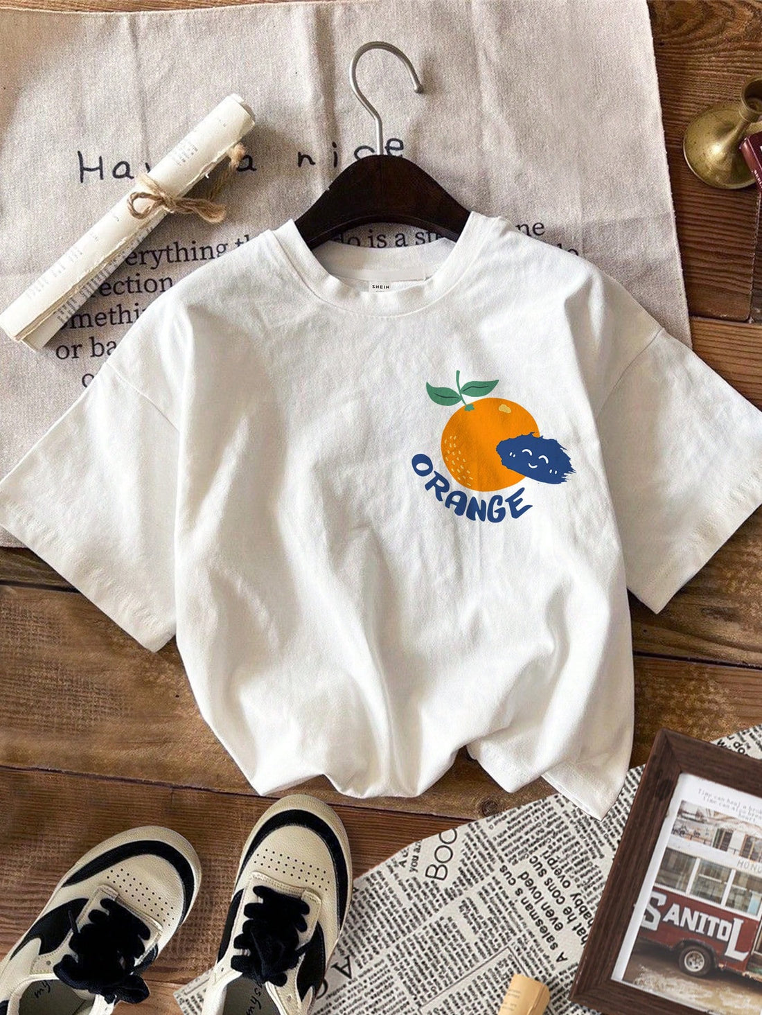 Get ready to turn heads this summer with our vibrant Orange Graffiti Graphic Tee! This playful white t-shirt features a bold, colorful design that pops against its crisp short sleeves and classic round neck. Perfect for sunny days and casual outings, it adds a fun splash of style to any outfit while keeping you cool and comfy. Embrace the season with a tee that’s as lively and bright as your summer adventures!