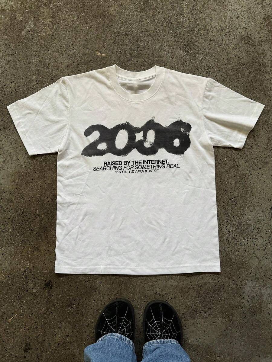 Front flat lay of white crew-neck T-shirt with distressed 2000s internet graphic and denim styling