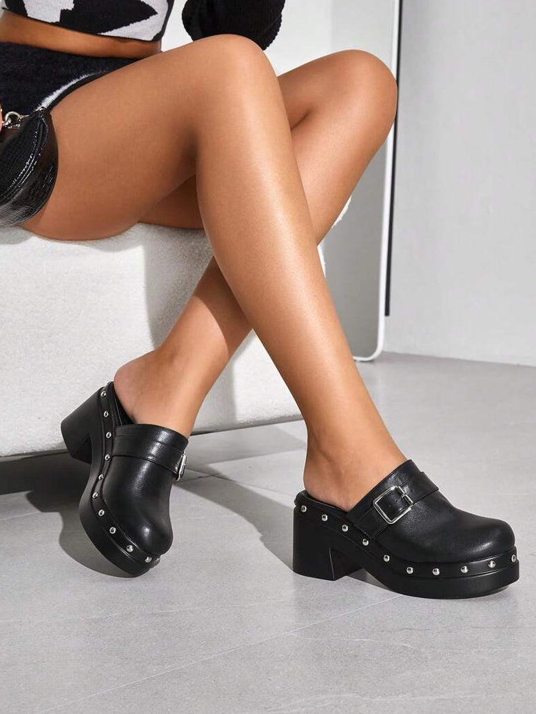 Exude Nocturnal Sophistication in Our Trendy Black Mules with Thick Sole!

Experience the breathtaking fusion of subculture heritage and sharp, modern architectural tailoring. This stunning buckle-accented shoe is meticulously designed for the woman who values a high-fashion, "quiet luxury" approach to edgy seasonal dressing—the ultimate centerpiece for prestigious city retreats, exclusive midnight soirées, and high-authority Y2K-inspired outings.

Iconic Punk & Buckle Artistry: Featuring a masterfully cura