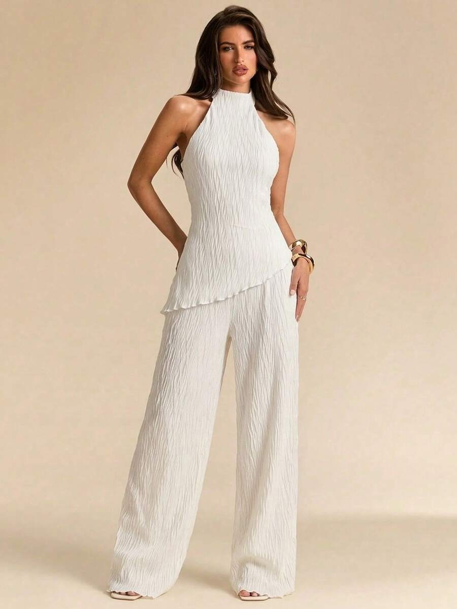 Make a statement with this effortless two-piece set designed for modern style. The halter top features a daring backless cut and asymmetrical silhouette that flatters while keeping things fresh and contemporary. Pair it with the relaxed wide-leg pants for a balanced, sophisticated look that works from casual outings to evening plans. Perfect for those who love bold fashion choices without sacrificing comfort. Mix and match with your favorite accessories to create endless outfit combinations.