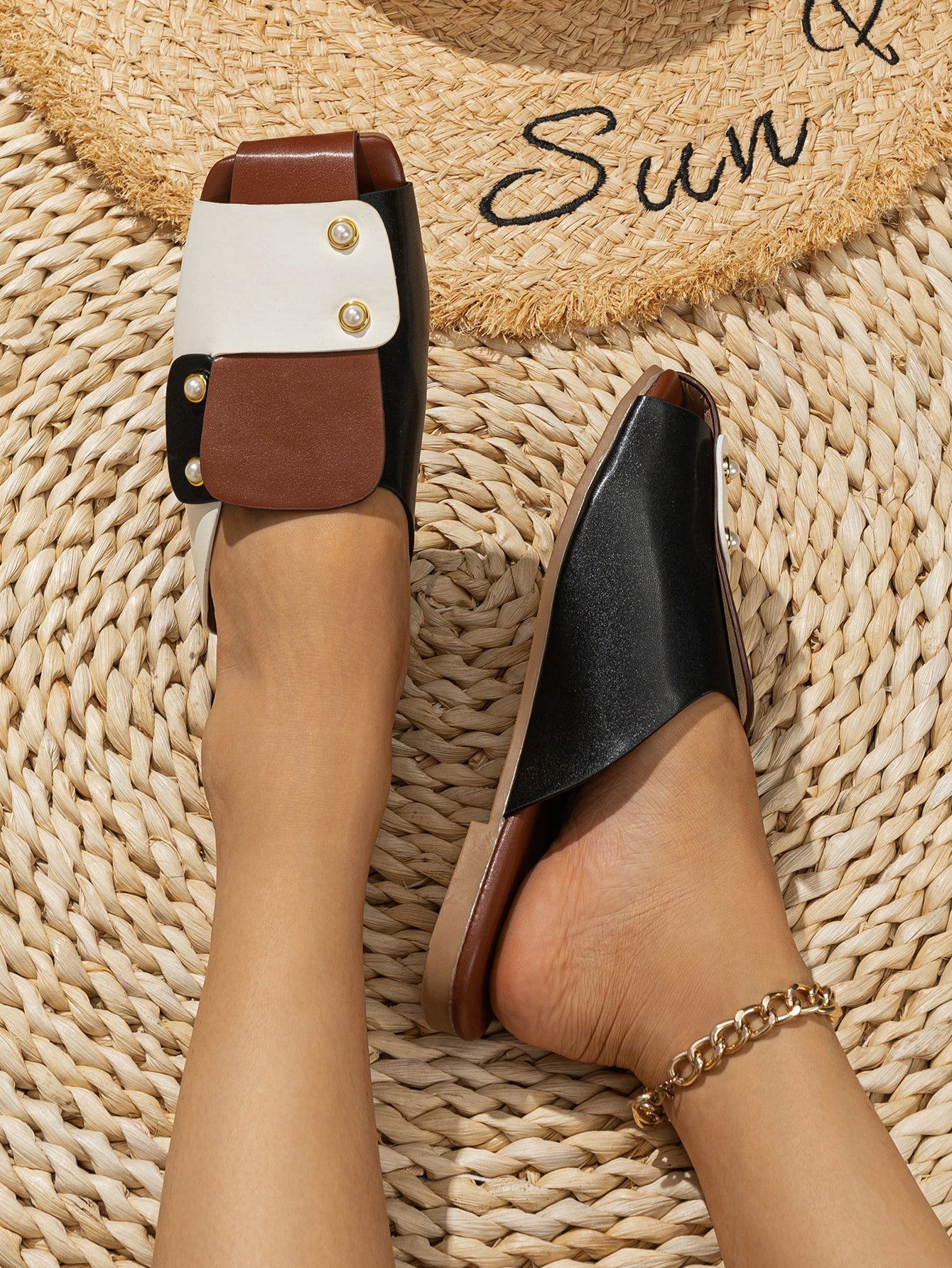 Slip on these chic sandals for a trendy two-tone look that will elevate your summer style! Made with faux pearls, these slides will add a touch of sophistication to any outfit. Perfect for strolling on the beach or exploring the city with a fun and playful attitude.