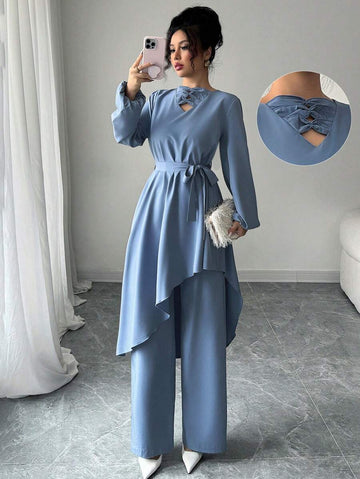 Elevate your fall wardrobe with this chic 2-piece set that's equal parts trendy and effortless. The tie-front top features an eye-catching asymmetrical hem that adds movement and personality to your look, while the coordinating pants keep things polished and put-together. Perfect for transitioning from casual coffee dates to weekend adventures, this solid-color combo works with everything in your closet. Mix, match, or wear them together—either way, you're serving style.