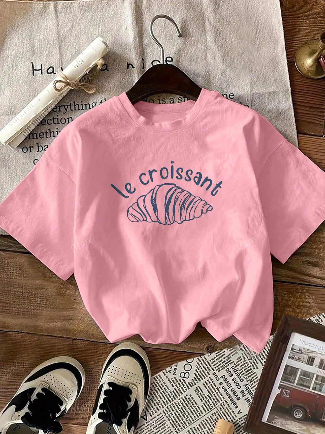 Indulge your fashion cravings with this trendy t-shirt featuring a mouth-watering croissant print. Made with a comfortable round neck and short sleeves, this casual tee is perfect for any occasion. A must-have for any fashion-forward woman! (Hungry yet? Get ready to satisfy your style cravings with this croissant t-shirt!)