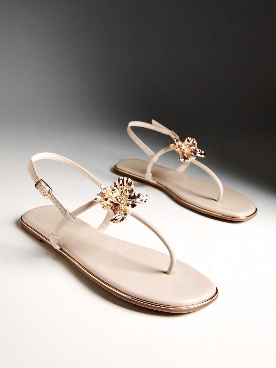 Nude floral T-strap flat sandals with gold flower charms