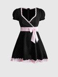 Front view of black polka dot A-line mini dress with pink lace trim and bow waist sash