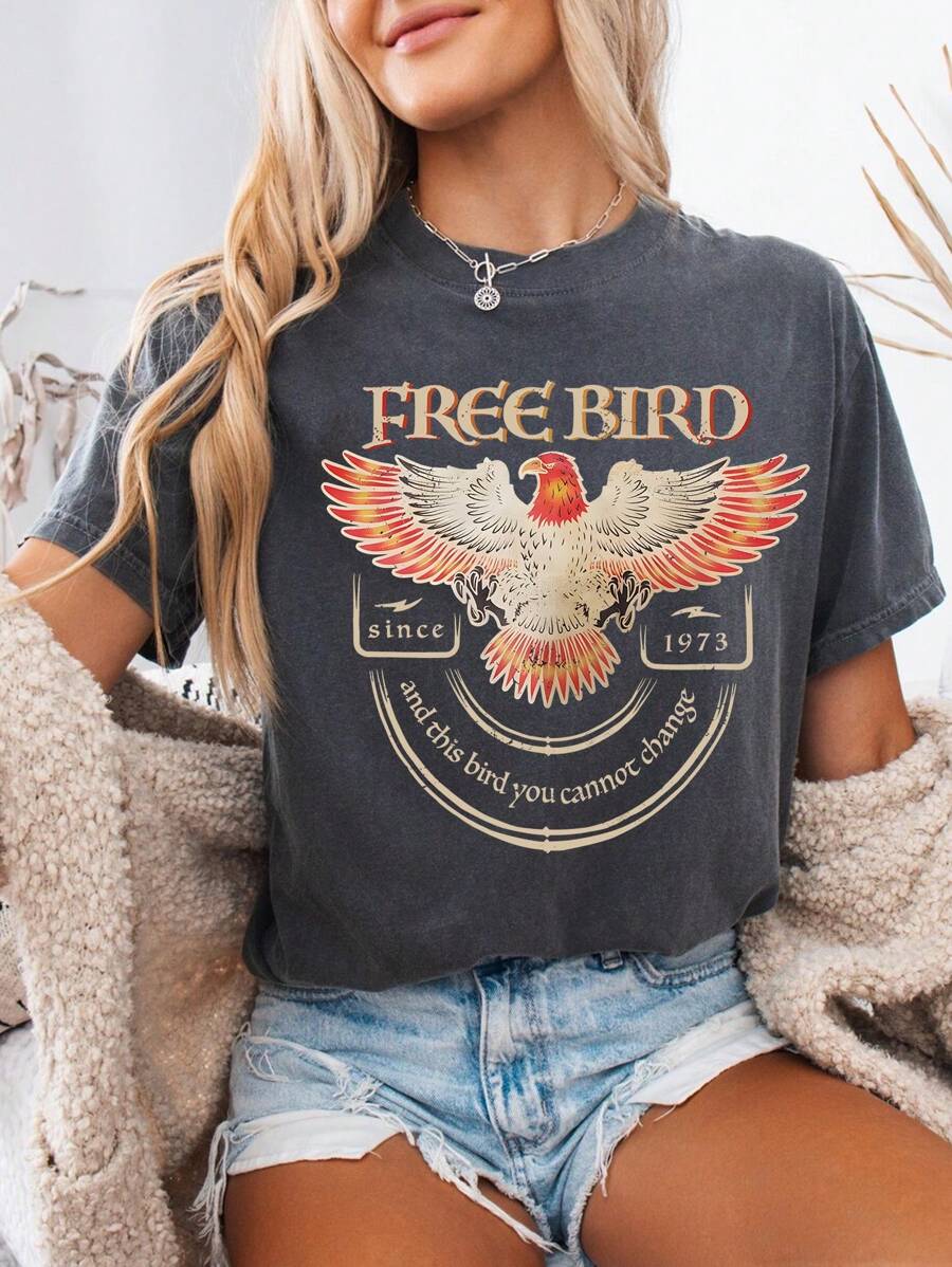 Front model view of washed grey Free Bird eagle graphic T-shirt styled with denim shorts