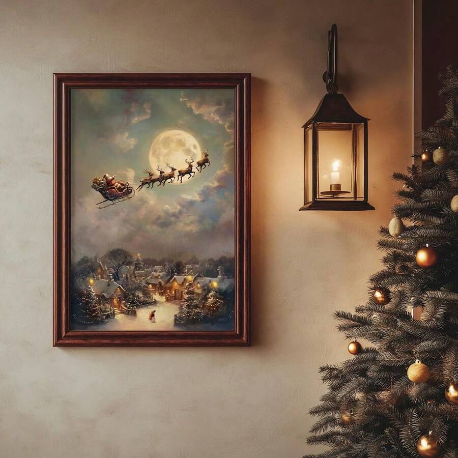 Framed Christmas canvas wall art showing Santa and reindeer flying over a snowy village, styled beside a tree and lantern.