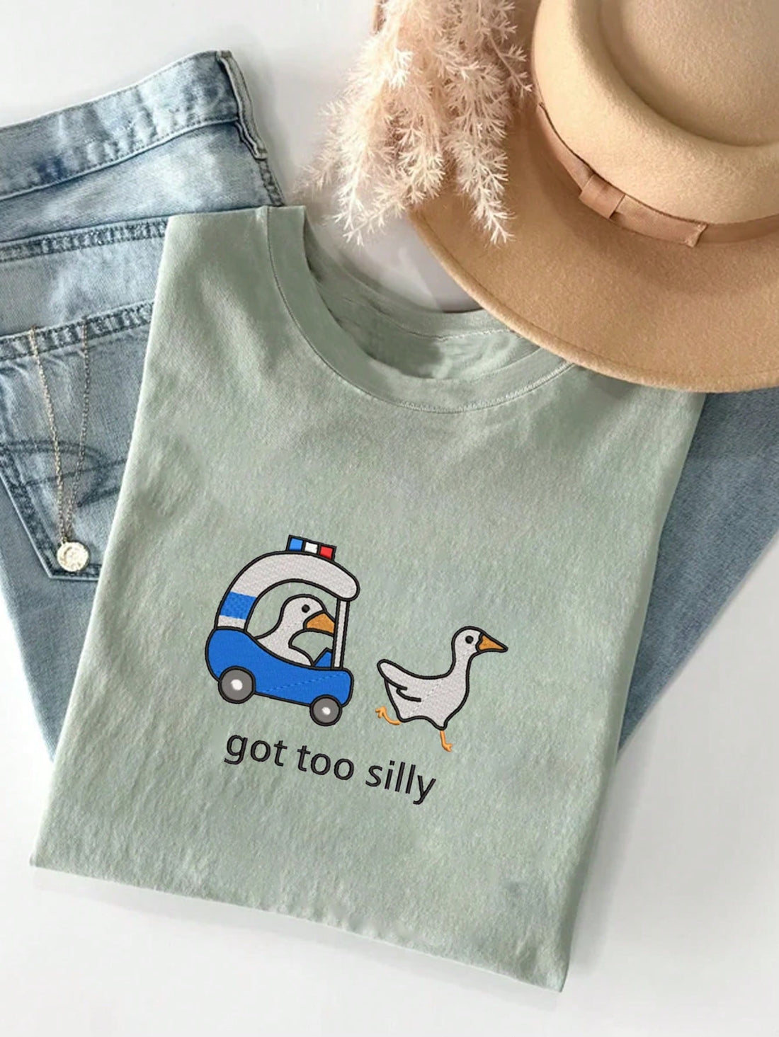 Introducing our Whimsical Goose Patrol tee for women! This funny embroidered graphic tee is a must-have for any animal lover. Show off your unique style while supporting the preservation of geese habitats. Made with high-quality materials for long-lasting comfort.