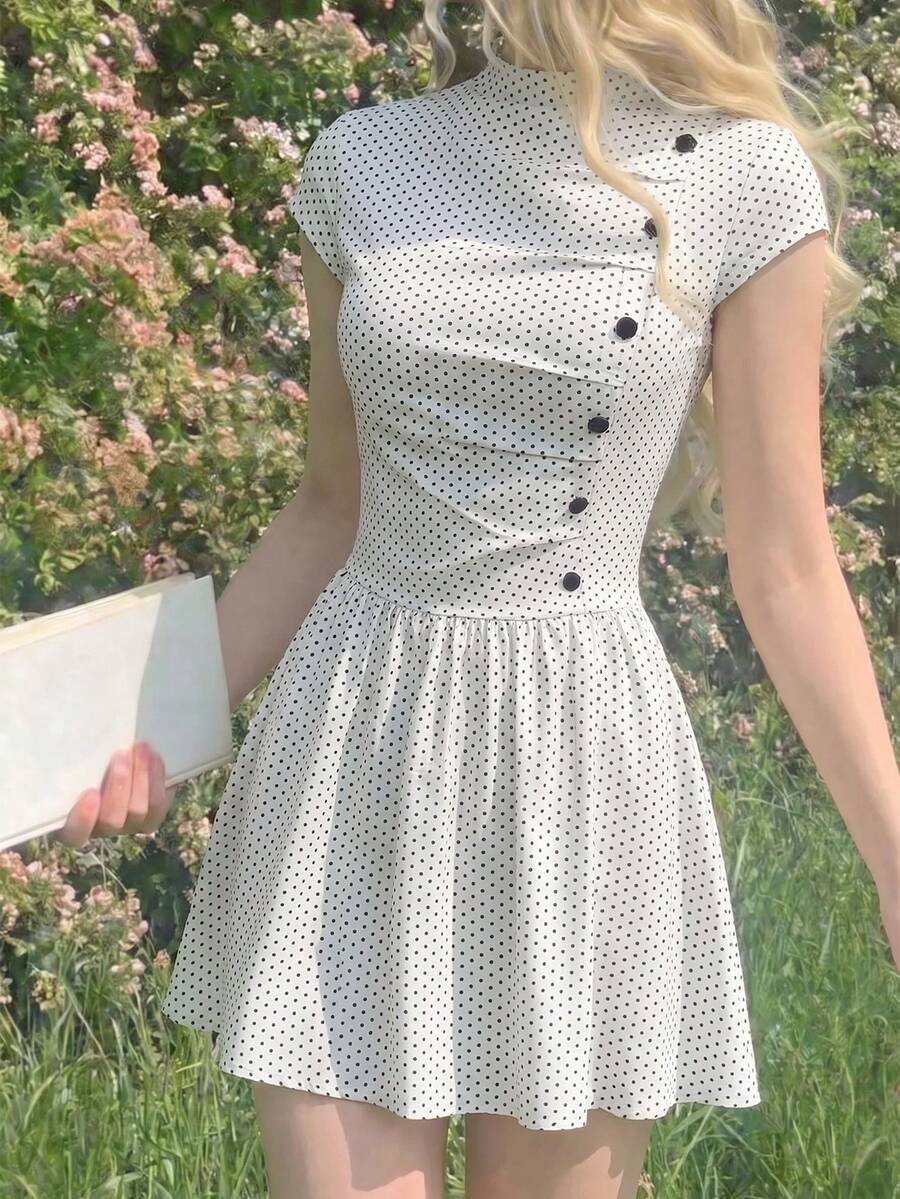 Model outdoors in ivory black polka dot mini dress with mock neck and flared skirt