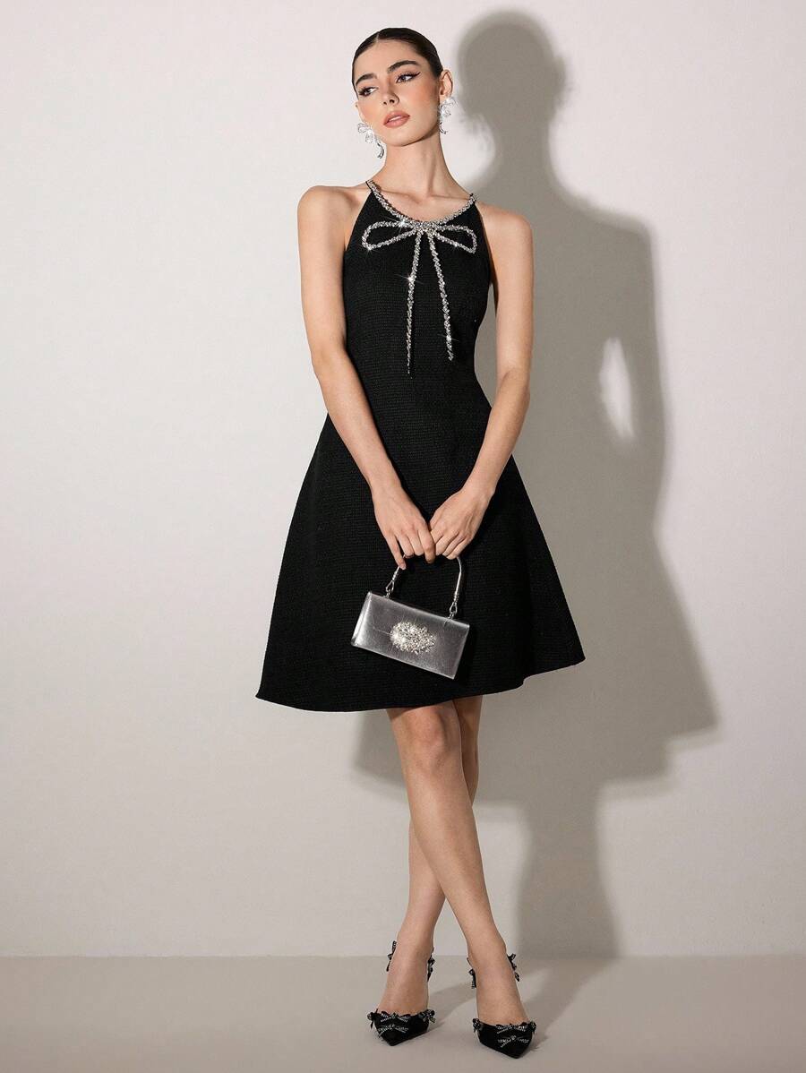 Elevate your elegance with this stunning sleeveless A-line dress that's pure sophistication with a playful twist. The delicate spaghetti straps and charming bowknot detail add a touch of whimsy, while faux pearl embellishments bring timeless glamour. The slim-fit bodice flatters your silhouette before flowing into a graceful A-line skirt that moves beautifully. Perfect for date nights, special occasions, or whenever you want to feel absolutely fabulous. This versatile piece transitions seamlessly from day t