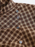 Close-up of brown plaid mini dress stand collar, diagonal button placket, and woven texture