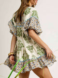 Rear three-quarter view of olive patchwork swing mini dress with contrast yoke and ruffle hem