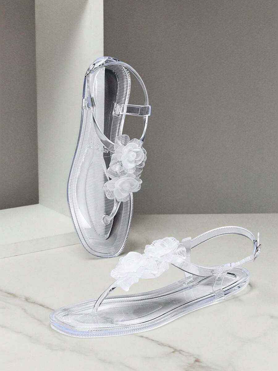 Step into effortless summer style with these clear jelly flat sandals, designed for all-day comfort and casual wear. The transparent upper showcases delicate floral decor details, creating a fresh, feminine look that pairs perfectly with any warm-weather outfit. Crafted from soft, flexible jelly material, these sandals mold to your feet for a custom fit. The flat sole provides reliable support for everyday activities, while the lightweight construction keeps your feet cool and comfortable throughout the day