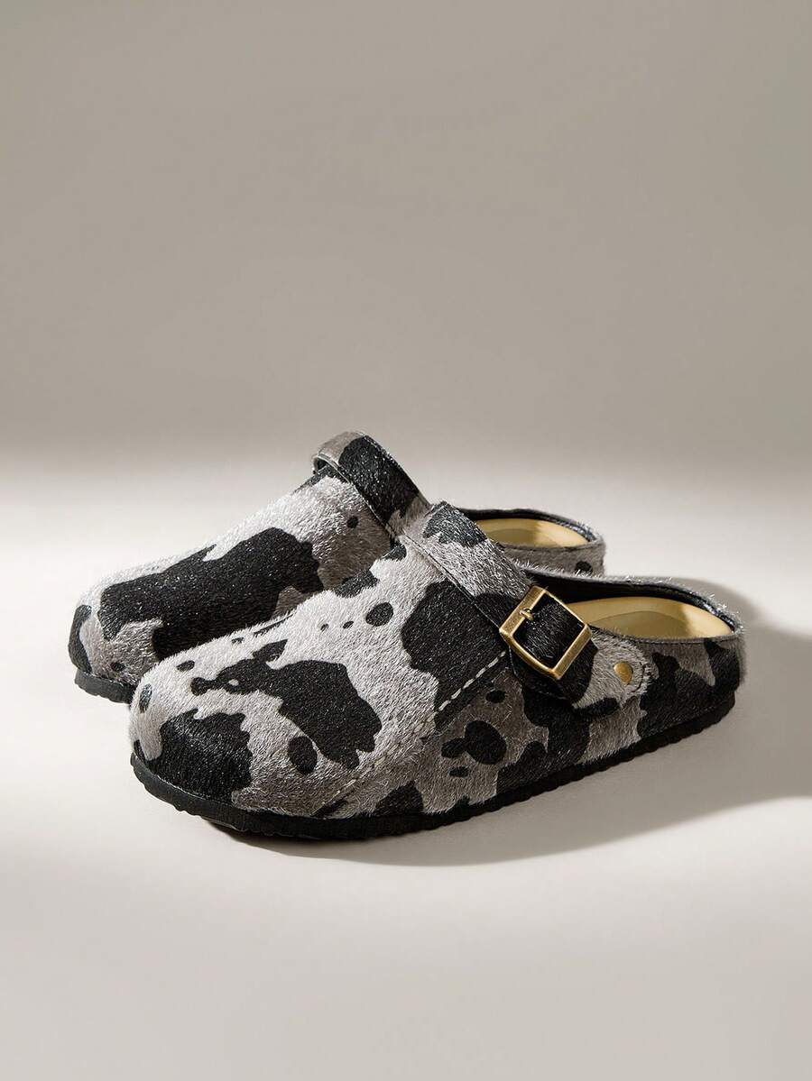 Step into comfort and style with these eye-catching women's cow print slip-on mules. Featuring a classic black-and-white pattern that makes a bold fashion statement, these mules combine effortless wearability with contemporary flair. The adjustable buckle strap ensures a customized fit throughout the day, while the slip-on design offers quick, convenient dressing. Versatile enough for casual outings or festive occasions, these mules deliver both personality and practicality. Whether you're refreshing your e