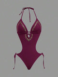 Front studio view of burgundy halter studded cutout one-piece swimsuit with deep V neckline and hip ties for beach party styling