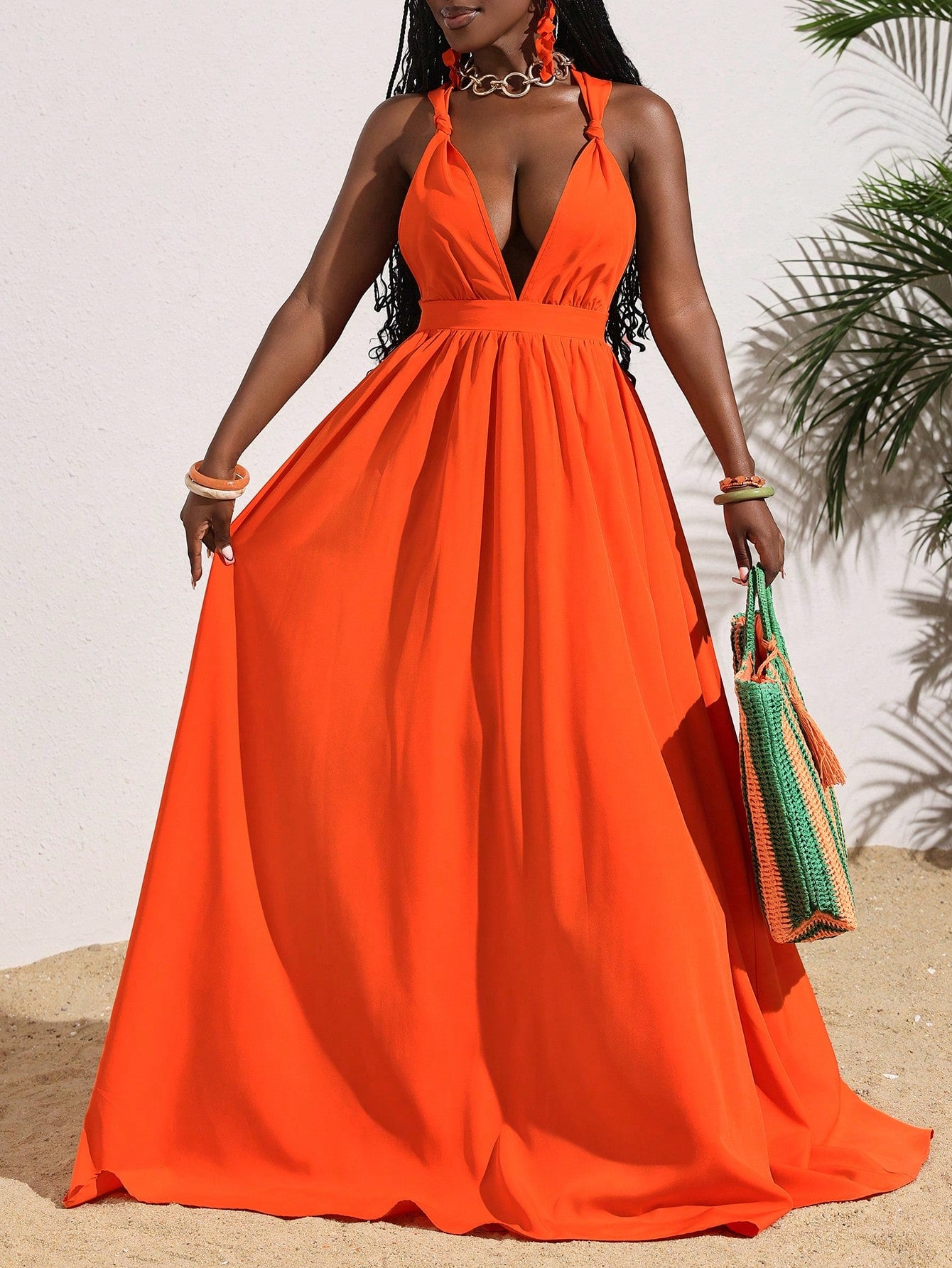 Get ready to turn heads in this flirty dress! Featuring a deep v-neck and backless design, it's the perfect outfit for your summer vacations. The vibrant orange color will make you stand out, while the lightweight and flowy fabric will keep you comfortable on even the hottest days. Don't forget to pack this must-have dress for your next trip!