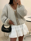 Front model view of greige-white chunky V-neck cardigan with gold buttons