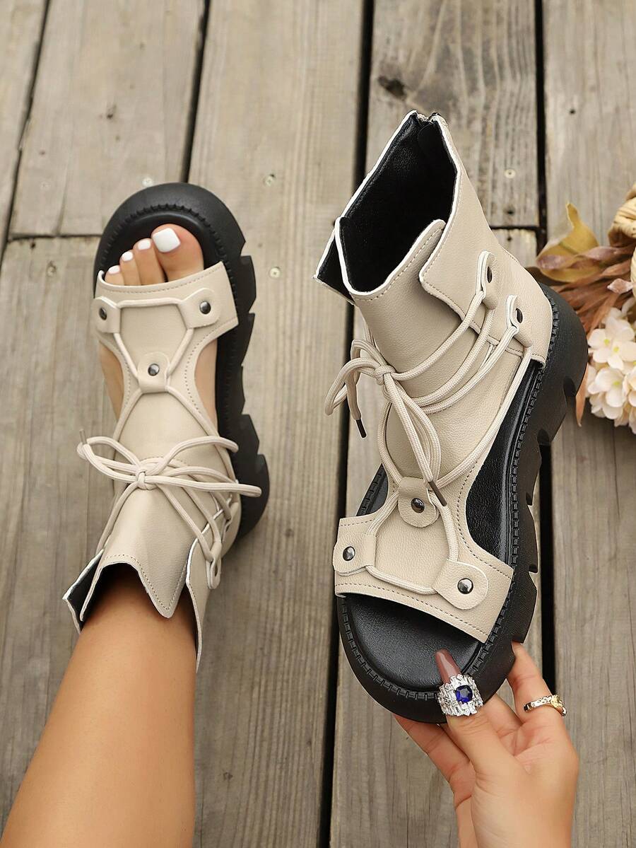 Front three-quarter on-foot view of black lace-up cutout wedge sandals