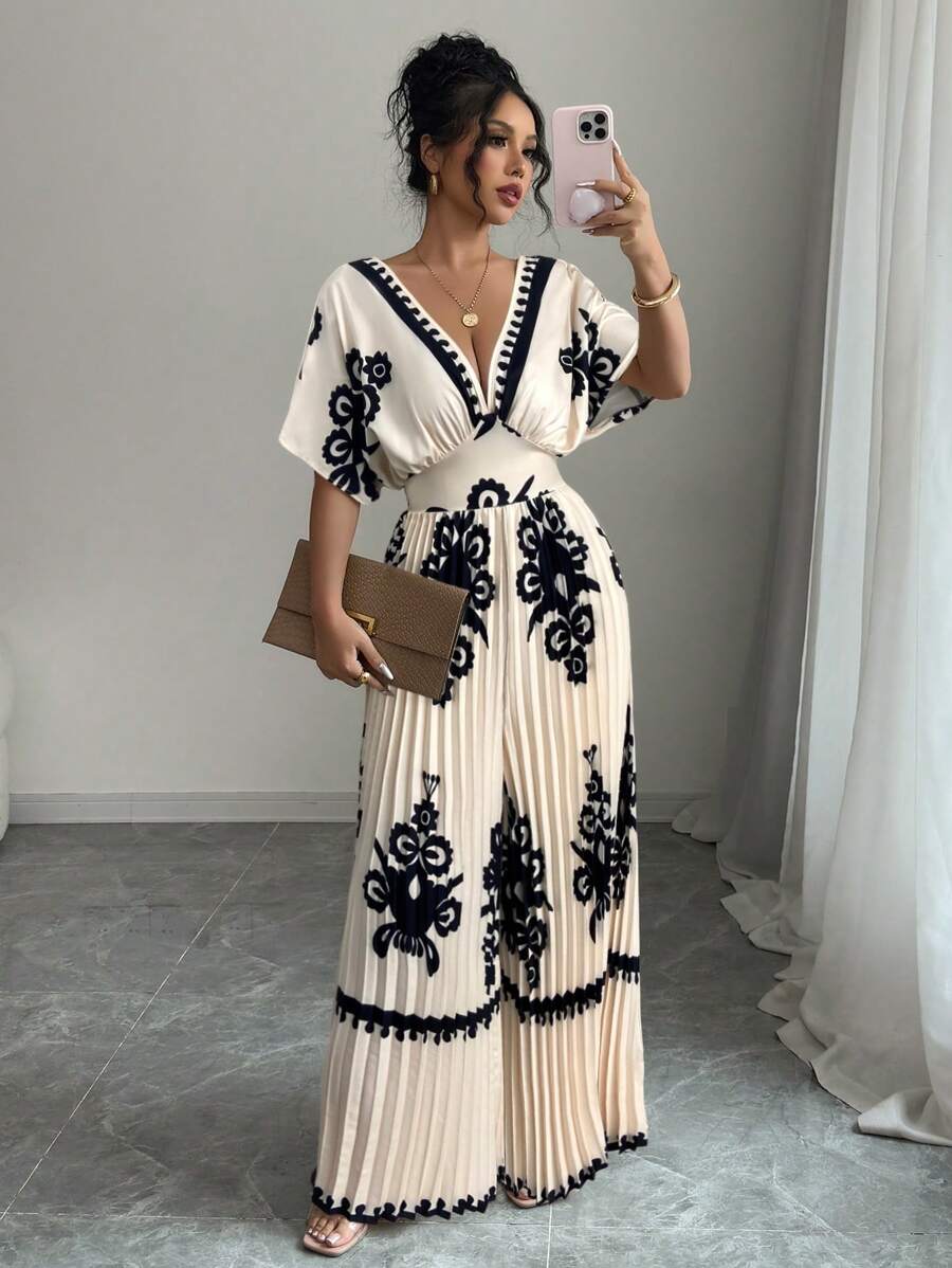 Make a statement in this eye-catching retro print jumpsuit designed for the modern traveler. The dramatic batwing sleeves and deep V-neckline create an effortlessly chic silhouette, while the pleated detailing adds movement and dimension. Perfect for vacation days, resort dinners, or anywhere you want to turn heads. The relaxed fit ensures comfort without sacrificing style, making it an instant wardrobe essential for bold fashion lovers.