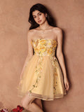 Embrace sunny days in this playful yellow mini dress, designed with delicate embroidered florals that add a touch of romance. The strapless cinching waist highlights your silhouette while keeping things light and breezy—perfect for spring and summer outings. Twirl freely and let your vibrant spirit shine in this charming, flirty dress made to brighten any occasion.