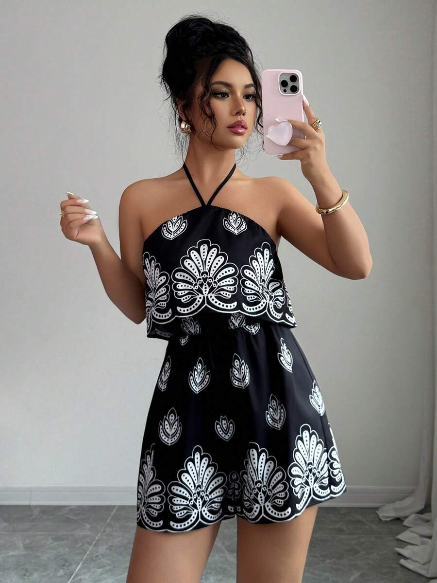 Mirror front view of black printed halter romper with layered ruffle bodice and gathered waist