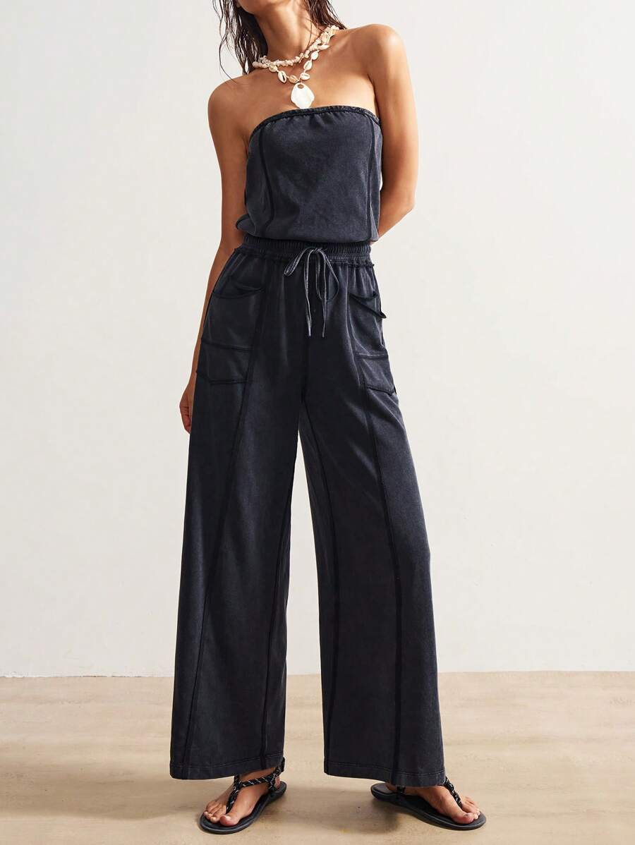 Front view of washed charcoal strapless wide-leg jumpsuit with drawstring waist and patch pockets