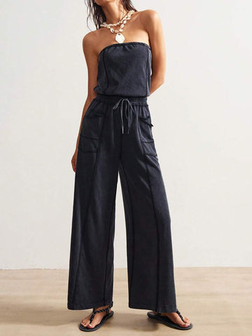 Front view of washed charcoal strapless wide-leg jumpsuit with drawstring waist and patch pockets