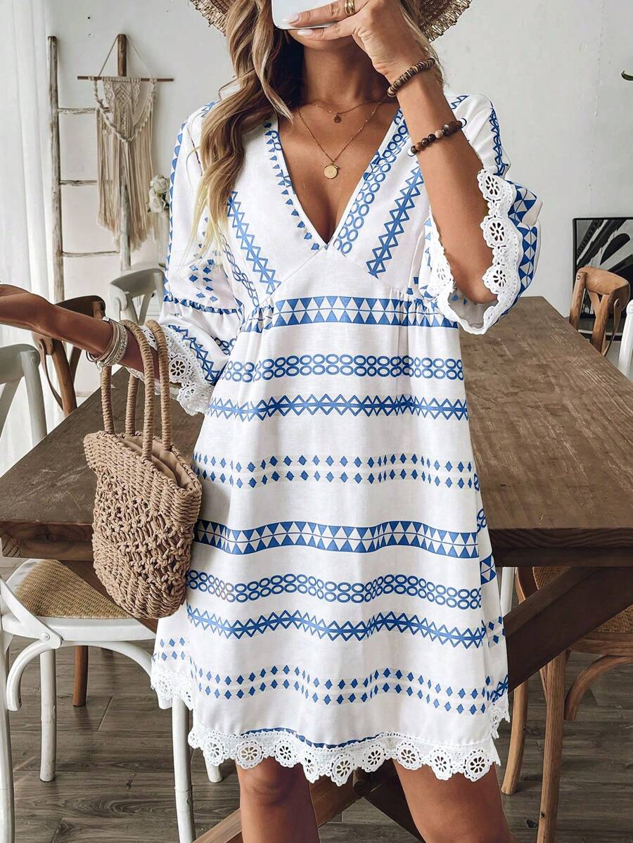 Front close view of blue geometric V-neck short dress with bell sleeves and white lace trim
