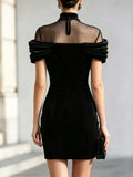 Back view of black mini dress with sheer mesh panel, high collar and center closure