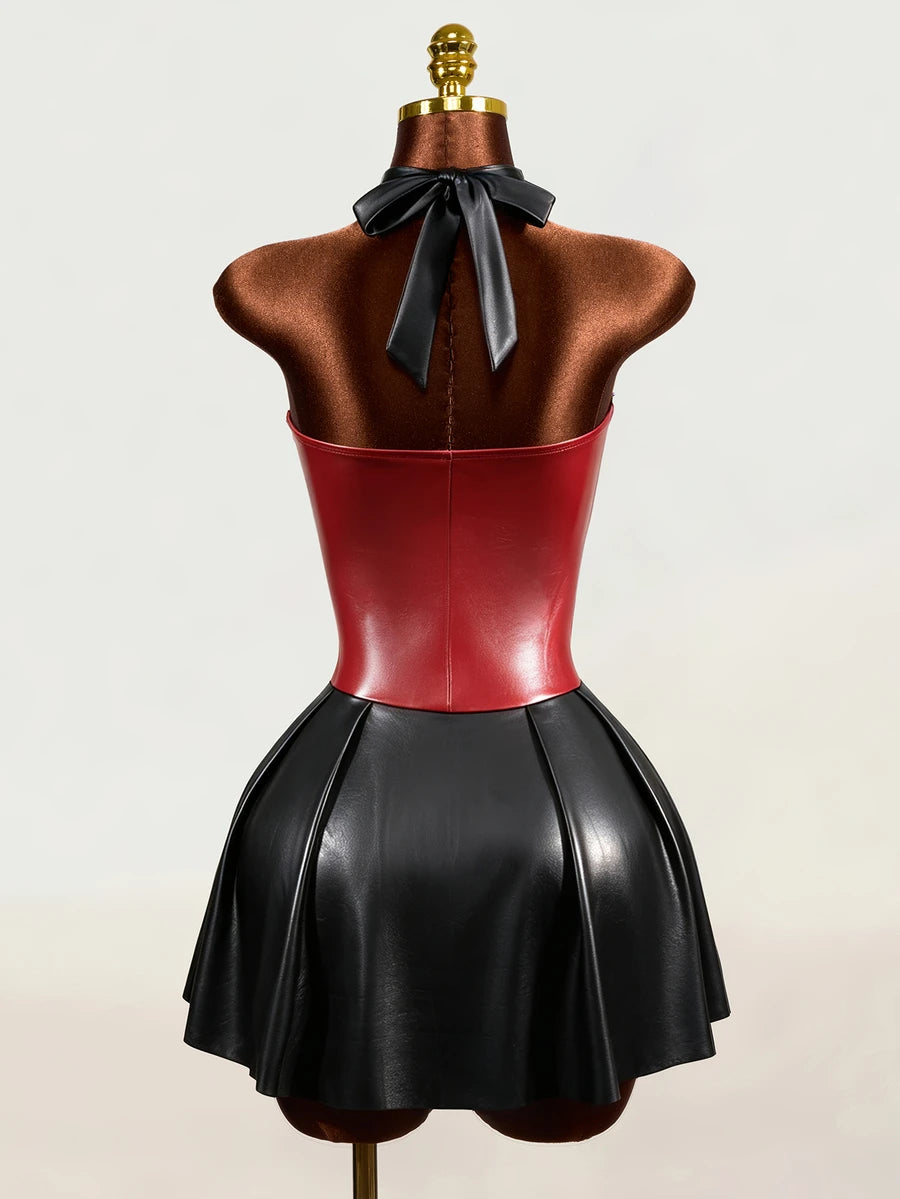 Back view of black and red faux leather halter mini dress with open back and neck bow