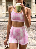 Woman wearing a pink check tank and matching cycling shorts outdoors