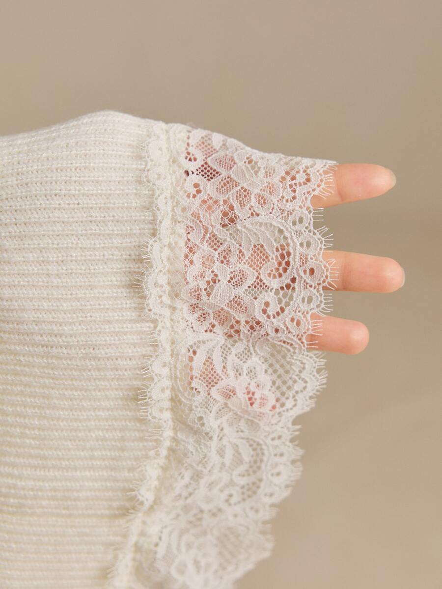 Close-up of the ivory rib-knit sleeve ending in floral openwork lace cuff trim