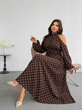 Seated front view of brown polka-dot flared halter maxi dress