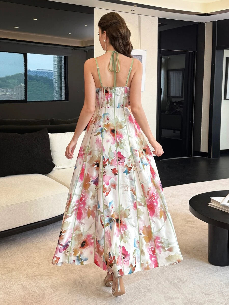 Seated front view of watercolor floral maxi dress with sage piping at an outdoor cafe