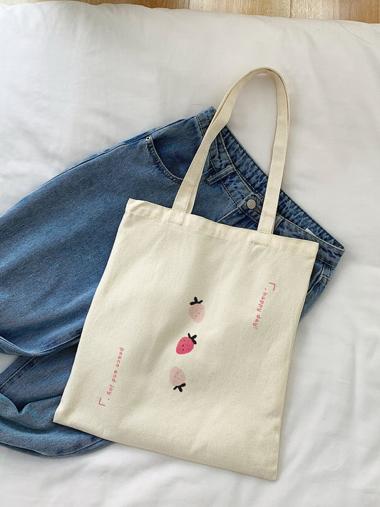 Introducing the Fruity Delight Strawberry Graphic Shopper Bag! This durable bag is perfect for all your back to school needs and beyond. Featuring a fun and stylish strawberry slogan graphic, you'll make a statement while staying organized. Made with quality materials, this bag is both functional and trendy.
