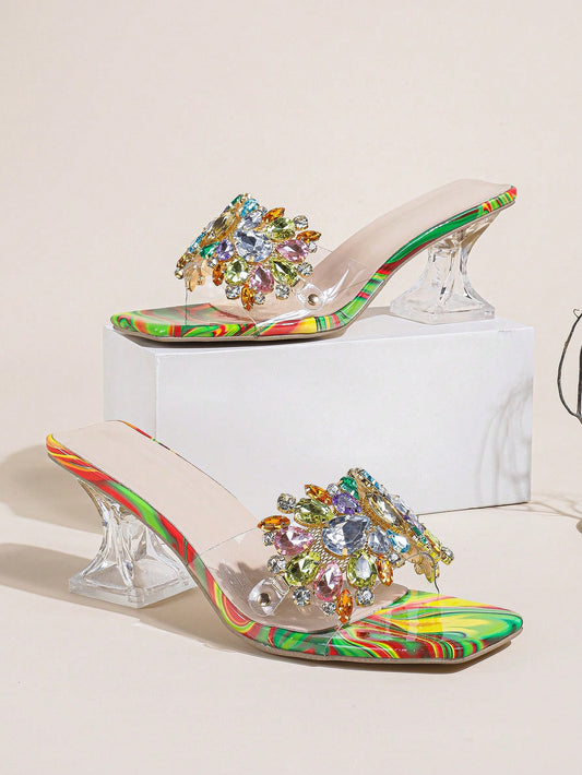 Elevate your shoe game with our Glamorous Rhinestone Clear Sculptural Heeled Sandals. The perfect blend of style and comfort, these PVC mule sandals add a touch of glamour to any outfit. Featuring stunning rhinestone embellishments and a sculptural heel for added elegance. A must-have for every fashion-forward woman.