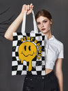 This Smiling Face Gingham <a href="https://canaryhouze.com/collections/canvas-tote-bags" target="_blank" rel="noopener">Canvas Tote Bag</a> is both fun and fashionable! Made with durable canvas, it features a unique smiling face design in a classic gingham pattern. Perfect for adding a touch of personality to your everyday look, while still being practical for carrying your essentials.