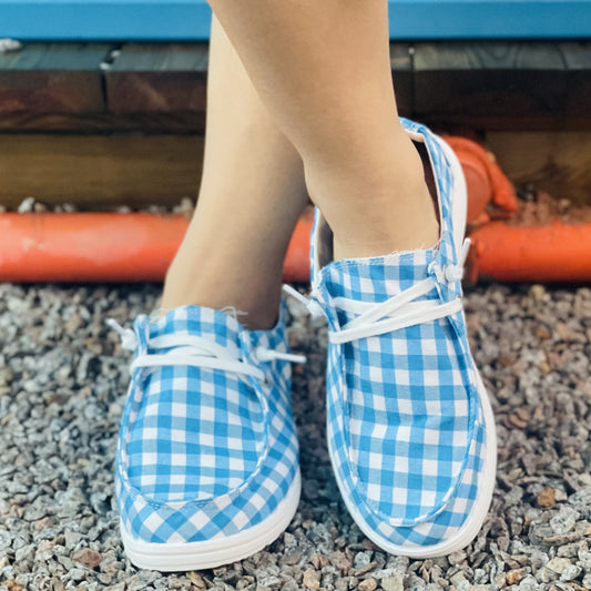 These lightweight women's canvas shoes offer both comfort and style. The blue and white plaid pattern canvas uppers are constructed with breathable materials to keep your feet cool and dry. The shoes feature casual lace-up closures and are designed to be lightweight, making them perfect for outdoor activities.